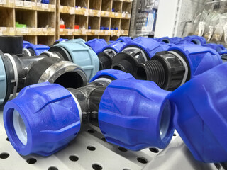 Colorful connectors displayed on a hardware store shelf for plumbing needs