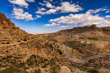 Widok na skaliste góry Dahar, tapeta. Niebieski kolor nieba i palące słońce, skała, kamień, górski krajobraz, egzotyczny kraj, Tunezja © anettastar