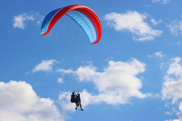 Tandem Paraglider flying in a blue sky	