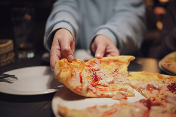 Freshly prepared thin crust pizza with chili peppers on a dark table in an Italian restaurant