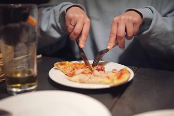Freshly prepared thin crust pizza with chili peppers on a dark table in an Italian restaurant