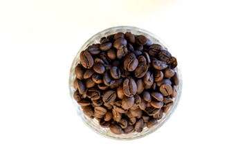 Close-up of fresh coffee beans in a container. Top-down view of roasted coffee.