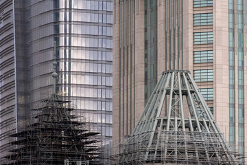 Close-up of modern skyscrapers under construction. Glass-covered buildings with steel structures.