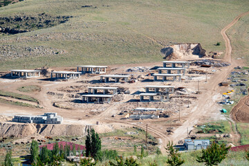 Rural houses under construction in a village. Concrete structures in the building process.