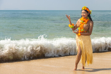 Hula Hawaii dancer dancing by the sea with the surf