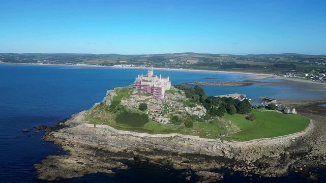 St Michael's Mount, Cornwall, England: DRONE VIEWS: St Michael's Mount and the coastline looking towards Penzance in the b/g; a causeway links the island, at low tide, to Marazion on the mainland (2).