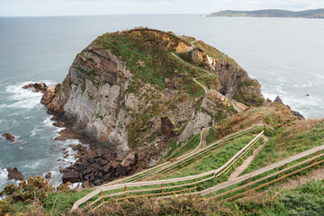 A scenic wooden walkway descends along the rugged cliffs of Galicia, ideal for travel and adventure.