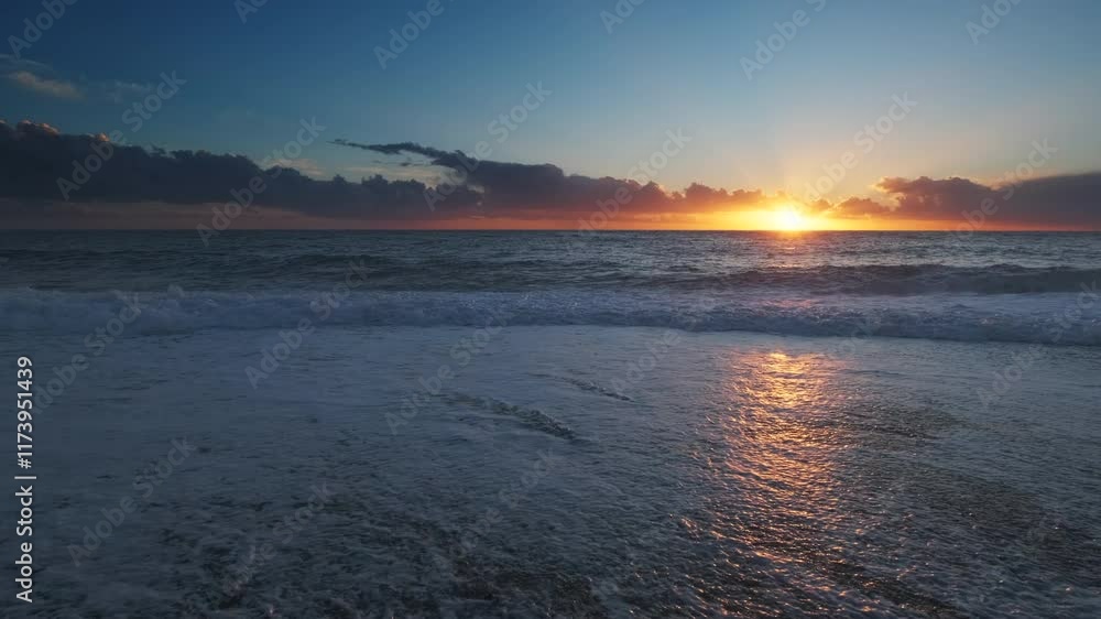 Wall mural stunning sunset over sea with vibrant colors reflecting on the water at the beach, 4k