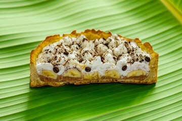 Authentic banoffee cake with banana and caramel sauce filling sprinkled with grated dark chocolate and coffee . English traditional pie
