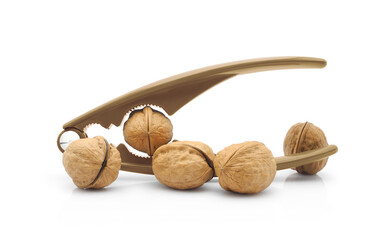 Whole walnuts with brown plastic lever nutcracker isolated on white background