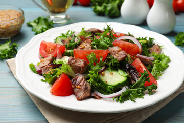 Delicious fresh tuna salad on light blue wooden table, closeup
