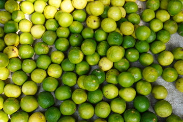 Fresh green and yellow lemons are kept in the basket 
