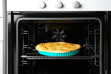 Baking dish with homemade apple pie in oven