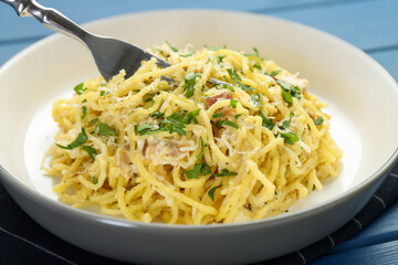 Delicious pasta Carbonara served on blue table, closeup