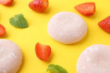 Delicious mochi and strawberries on yellow background, closeup