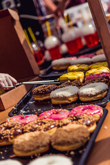 Donuts on counter of store, street food desserts are sold at festival food