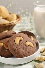 Tasty chocolate cookies with cashew on table, closeup