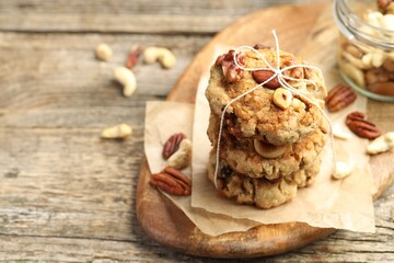 Tasty cookies with nuts on wooden table, closeup. Space for text
