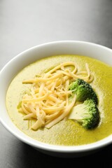 Delicious broccoli cream soup in bowl on gray table, closeup