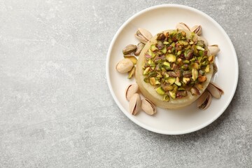 Delicious sweet semolina halva with pistachios on light grey table, top view. Space for text