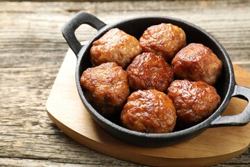 Tasty meatballs in baking dish on wooden table, closeup