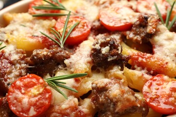Delicious pasta casserole with cheese, tomatoes, minced meat and rosemary, closeup