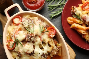 Flat lay composition with delicious pasta casserole on dark table