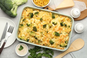 Tasty pasta casserole with cheese and broccoli served on grey table, flat lay