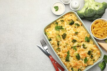 Tasty pasta casserole with cheese and broccoli served on grey table, flat lay. Space for text