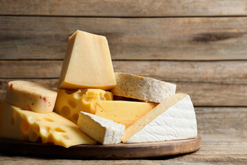 Different types of cheese on wooden table