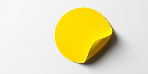A yellow circular paper sticker label isolated on a white background