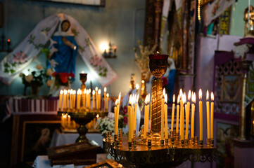 Flame of lit candles. Many yellow wax candles on a candlestick. Holy liturgy in a church or temple....