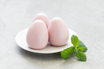 Easter dessert. Raspberry cream mousse egg. On a plate. Close-up. Light background