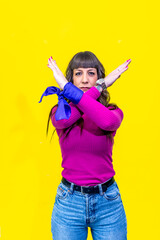 Woman making stop gesture with crossed arms and purple ribbons for women's day