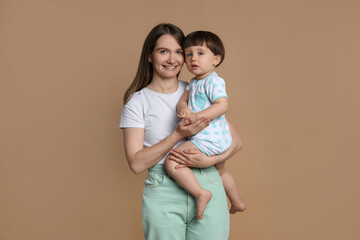 Family portrait of happy mother with her little son on beige background