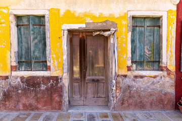 Italy, Burano. Worn facade of one of the colorful buildings the island is known for.