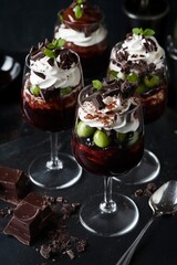 red velvet and cream cheese trifle desserts served in tall wine glasses, topped with whipped cream and chocolate shavings, elegant and decadent vibe