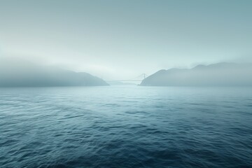 Naklejka premium A serene view of a foggy ocean landscape, showcasing calm waters and soft hues of blue and gray.