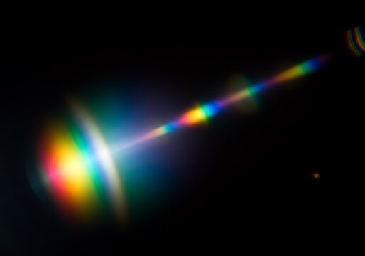 Prismatic light leaks with rainbow bokeh on dark background. Modern artistic design, abstract technology, digital effects.
