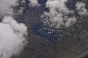 Fototapeta premium Iceland from airplane through clouds. Aerial scenic view of Iceland landscape. Travel vacation concept. Europe.