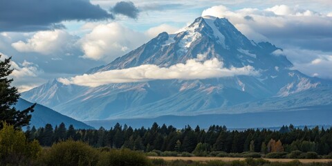 Majestic mountain peak surrounded by lush forest and dramatic clouds