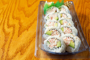 A view of a California roll in a plastic tray, on the right side of the frame. © DAVID
