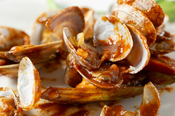 A closeup view of steamed clams with spicy cajun sauce.