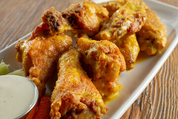 A closeup view of a plate of mango habanero chicken wings.