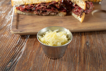 A view of a metal condiment cup of sauerkraut.