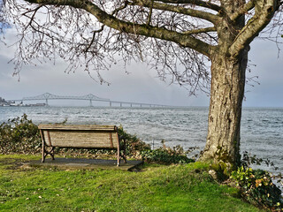 A bench along the Astoria river-walk with a view of the Astoria-Megler bridge