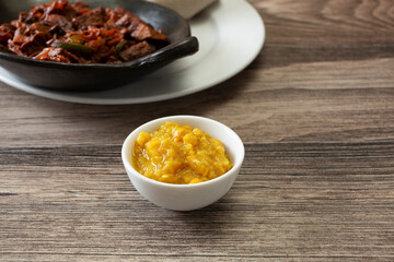 A view of a condiment cup of kik alicha.