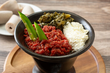 A view of a bowl of kitfo, with some injera.