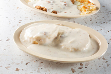 A view of a plate of biscuits and gravy.