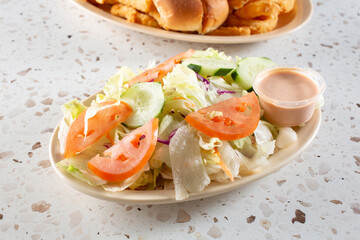 A view of a house salad, with thousand island dressing.